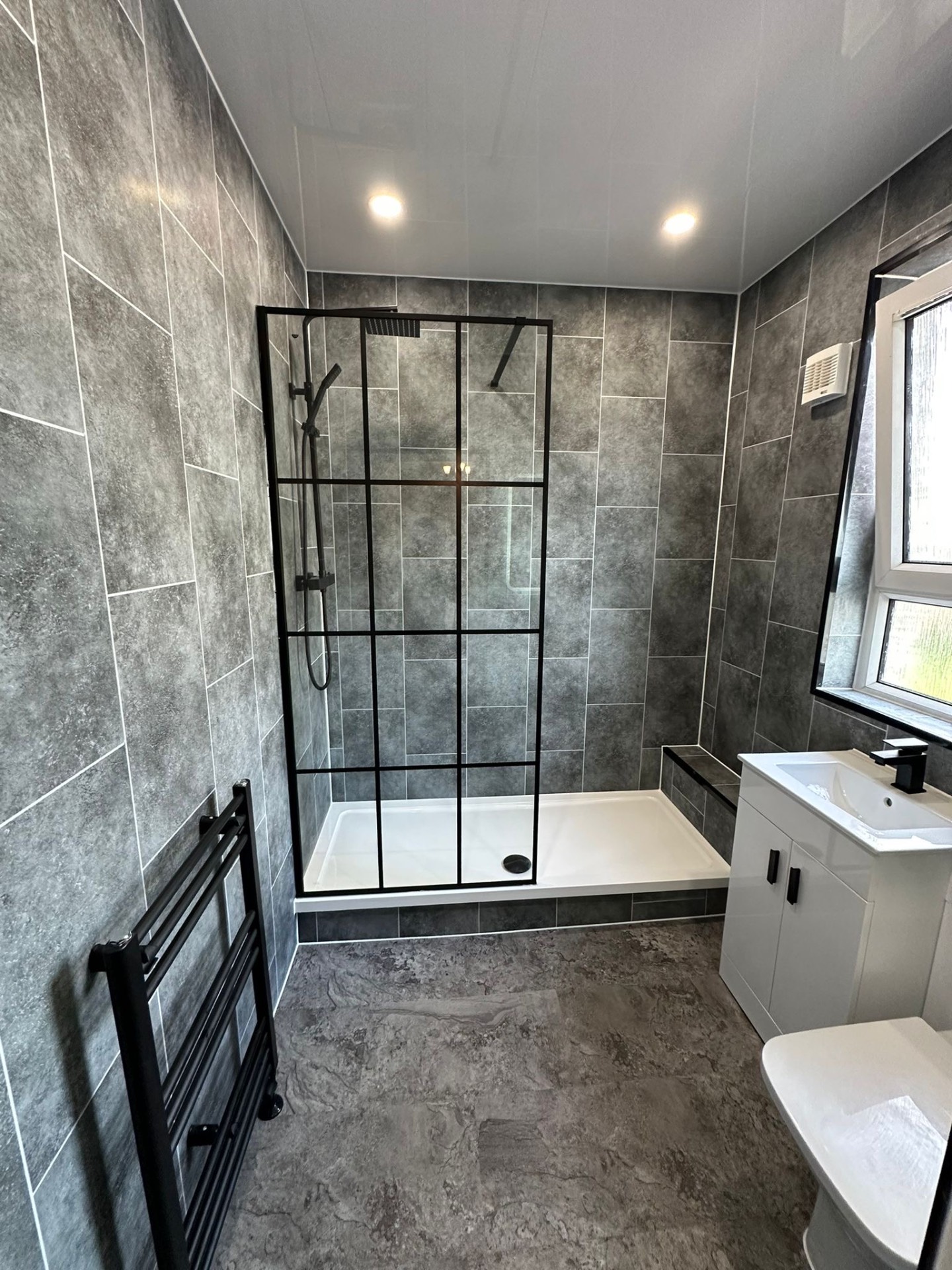 Grey slate bathroom with a black-framed walk-in shower